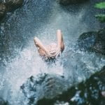 mujer duchandose bajo una catarata