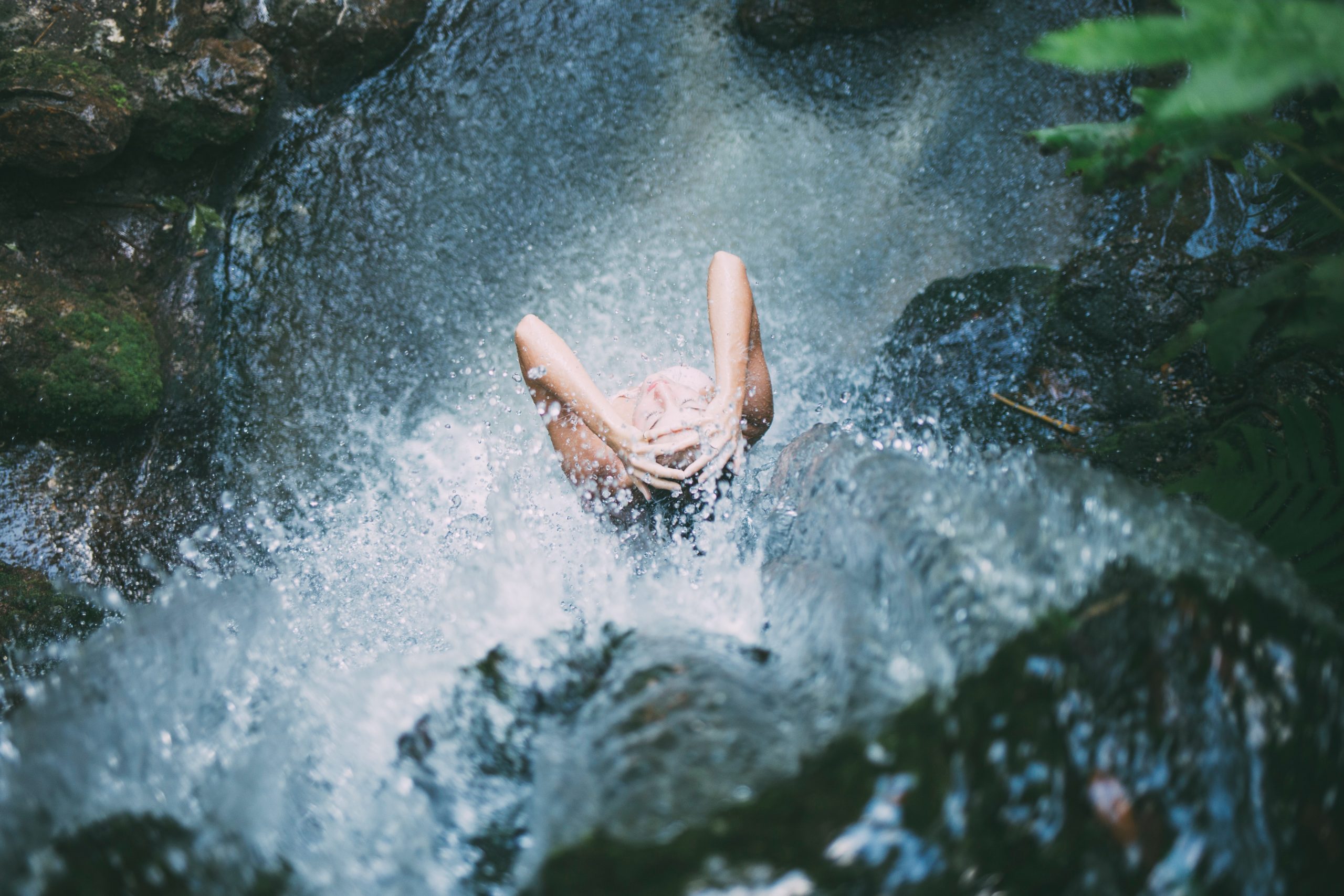 mujer duchandose bajo una catarata